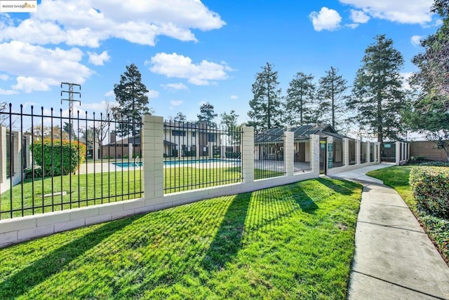 exterior space featuring a swimming pool and a yard