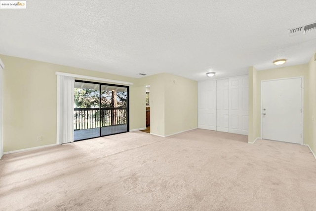 carpeted empty room with a textured ceiling