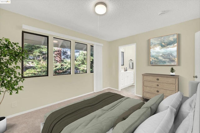 carpeted bedroom with connected bathroom and a textured ceiling