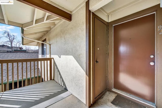 view of exterior entry with a balcony