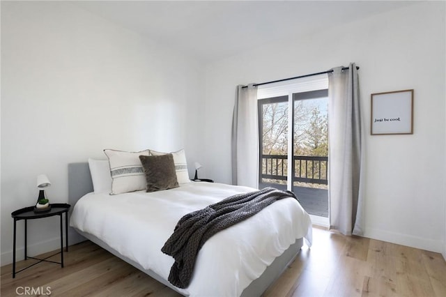 bedroom with access to exterior and light hardwood / wood-style flooring