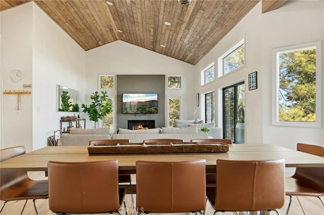 dining area with high vaulted ceiling and wooden ceiling