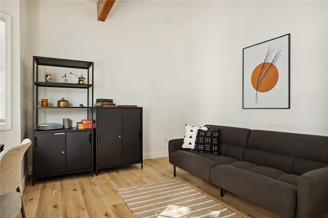 living room with beam ceiling and light hardwood / wood-style flooring