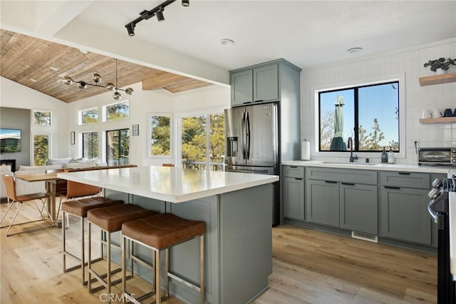 kitchen featuring sink, a kitchen island, and light wood-type flooring