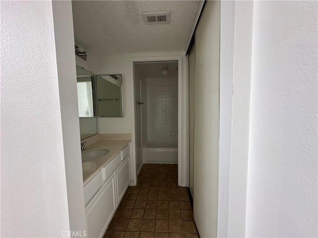 bathroom featuring vanity, tile patterned floors, and a textured ceiling