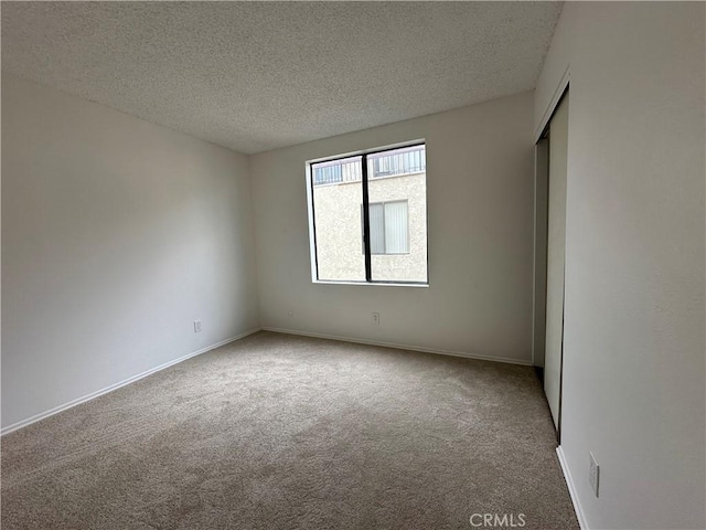 carpeted spare room with a textured ceiling