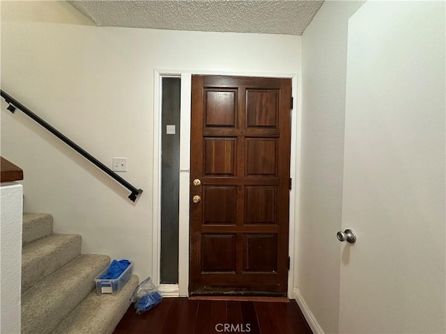 foyer featuring dark wood-type flooring and a textured ceiling