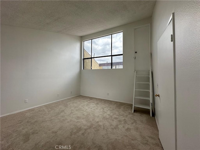 carpeted spare room with a textured ceiling