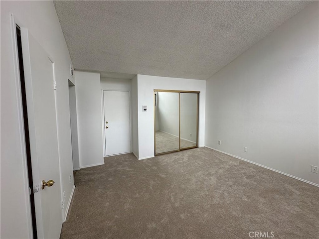 unfurnished bedroom featuring carpet flooring, a textured ceiling, and a closet