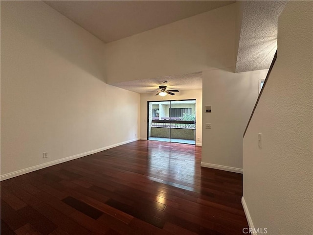 unfurnished living room featuring dark hardwood / wood-style flooring, a textured ceiling, and ceiling fan