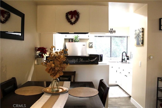 dining space featuring sink and light hardwood / wood-style floors