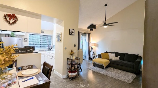 living room featuring dark hardwood / wood-style flooring, sink, high vaulted ceiling, and ceiling fan