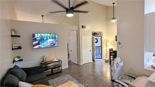 living room with dark wood-type flooring, ceiling fan, and high vaulted ceiling