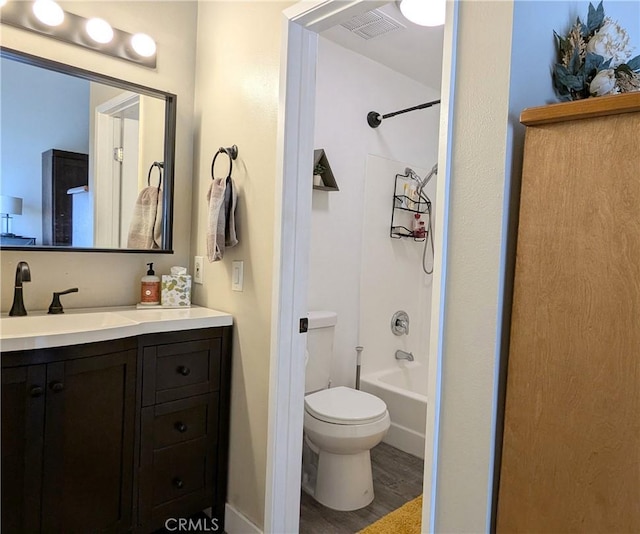 full bathroom with vanity, hardwood / wood-style floors, bathing tub / shower combination, and toilet