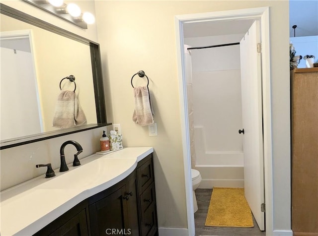 full bathroom featuring vanity, hardwood / wood-style floors, shower / washtub combination, and toilet