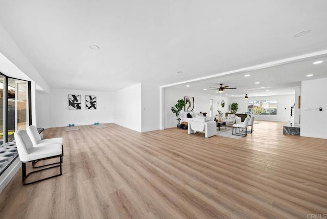 living room featuring ceiling fan and light hardwood / wood-style flooring