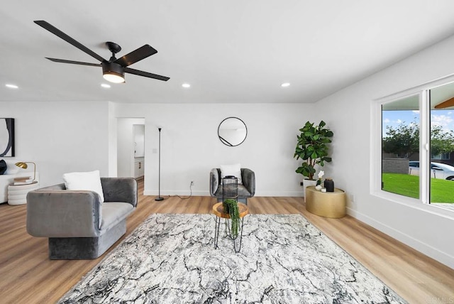 living room with light hardwood / wood-style floors and ceiling fan