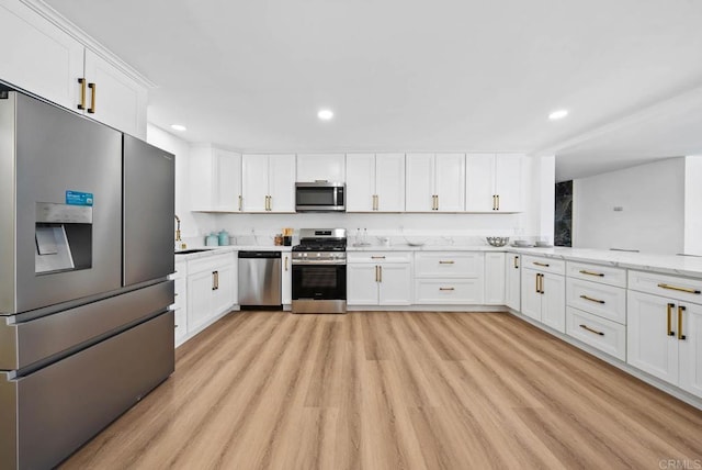 kitchen featuring white cabinetry, stainless steel appliances, and light hardwood / wood-style floors