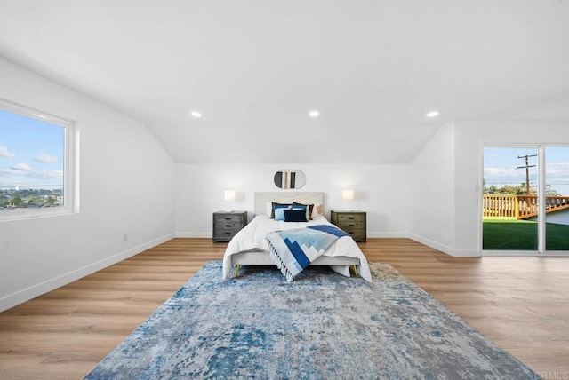 bedroom featuring lofted ceiling, multiple windows, access to outside, and light hardwood / wood-style flooring