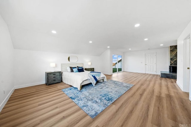 bedroom with lofted ceiling and light wood-type flooring