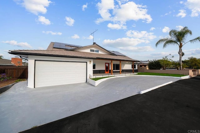 view of front facade with a garage and solar panels