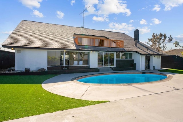 rear view of property with a patio and a lawn