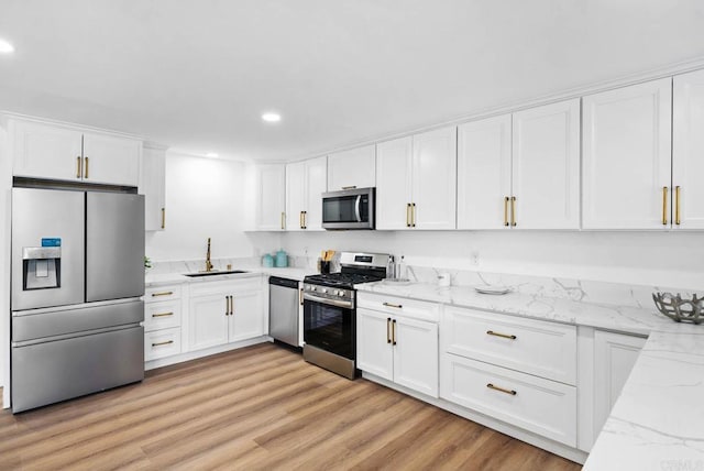 kitchen with stainless steel appliances, sink, and white cabinets