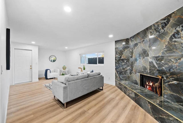 living room with light hardwood / wood-style floors and a tile fireplace