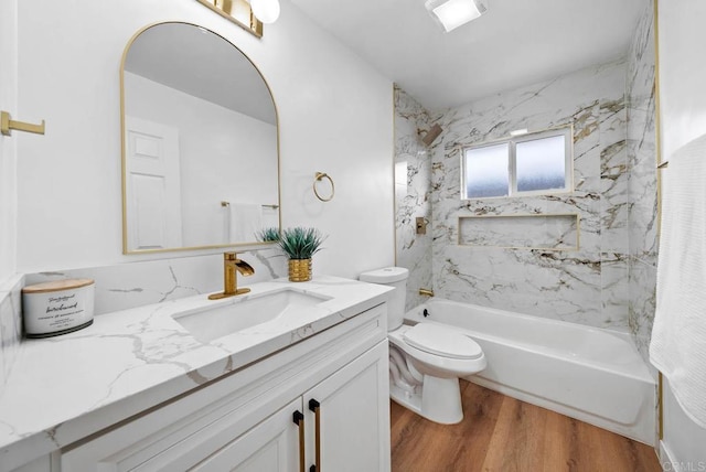 full bathroom with vanity, hardwood / wood-style flooring, toilet, and tiled shower / bath combo