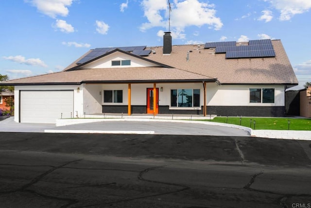 view of front facade featuring a garage and solar panels