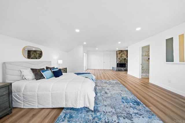 bedroom featuring a fireplace and wood-type flooring