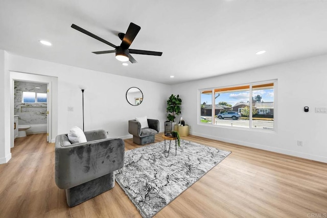 living room with ceiling fan and light hardwood / wood-style floors