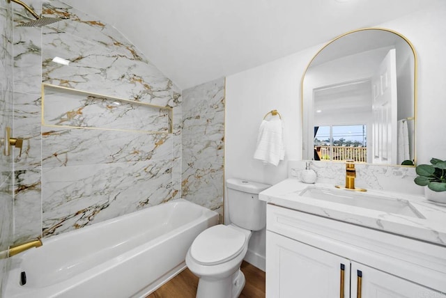 full bathroom featuring lofted ceiling, hardwood / wood-style flooring, vanity, toilet, and washtub / shower combination