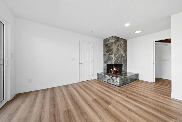 unfurnished living room featuring light hardwood / wood-style flooring and a premium fireplace