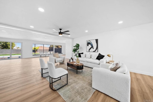 living room featuring ceiling fan and light wood-type flooring