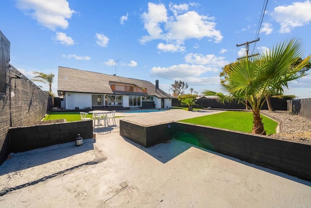 view of front of home with a pool and a patio area