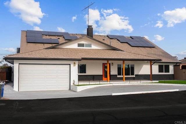 view of front of property with a garage and solar panels