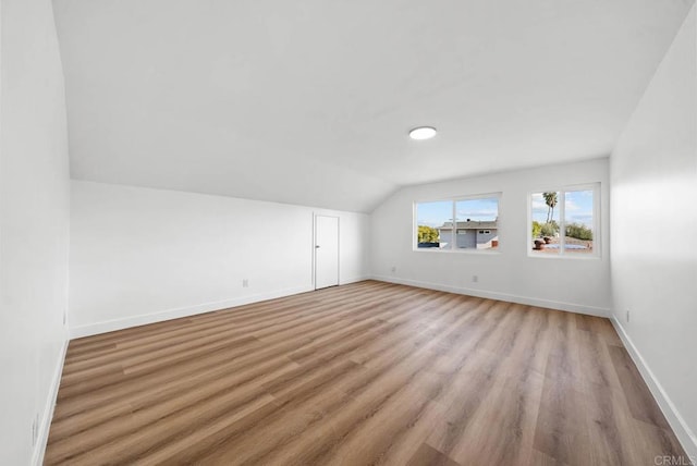 bonus room featuring lofted ceiling and light wood-type flooring