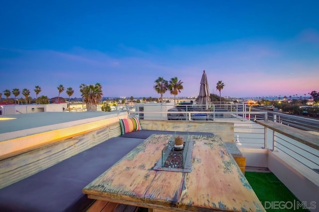 patio terrace at dusk featuring a balcony