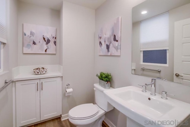 bathroom featuring toilet, sink, and hardwood / wood-style floors