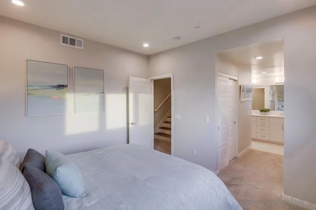 carpeted bedroom featuring ensuite bath