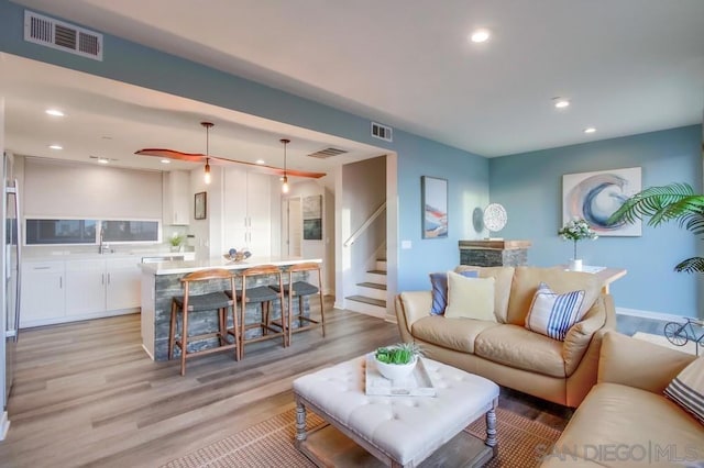 living room with sink and light hardwood / wood-style flooring