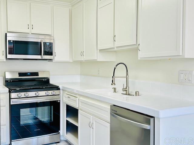 kitchen with white cabinetry, sink, and stainless steel appliances