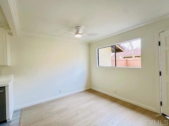 empty room featuring ceiling fan, ornamental molding, and light hardwood / wood-style flooring