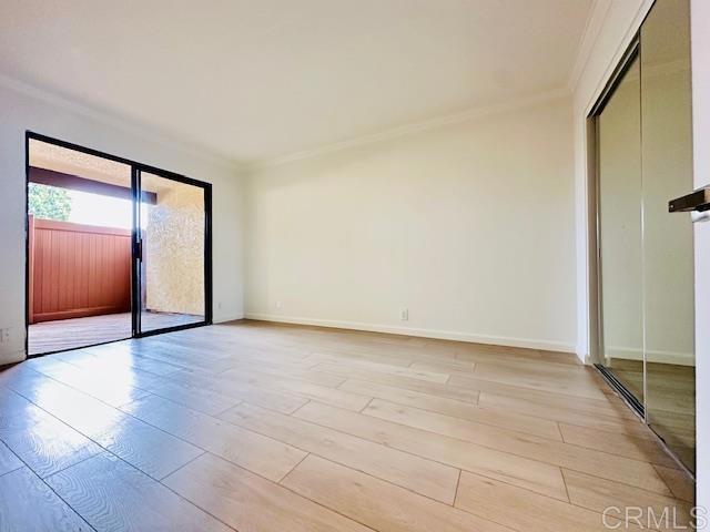 unfurnished bedroom featuring a closet, ornamental molding, and light hardwood / wood-style floors