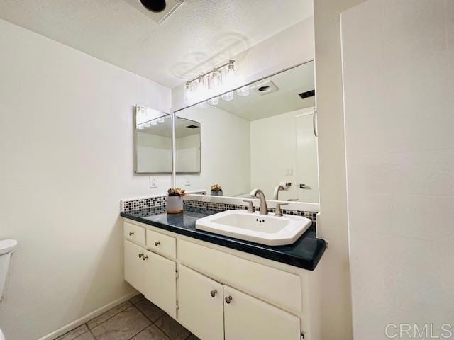 bathroom featuring tile patterned flooring, vanity, and toilet