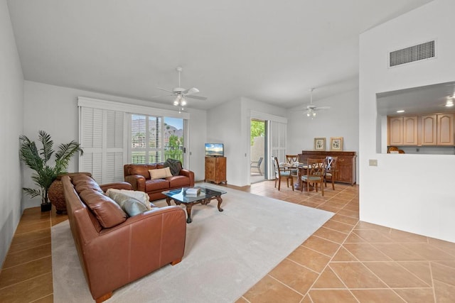 living room with light tile patterned flooring, lofted ceiling, and ceiling fan