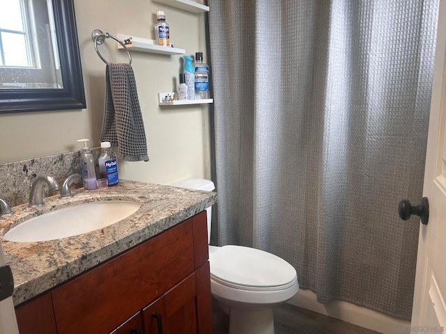 bathroom with a shower with curtain, vanity, hardwood / wood-style flooring, and toilet