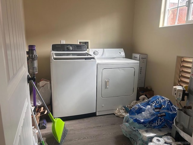 washroom with hardwood / wood-style floors and washing machine and clothes dryer