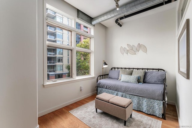 bedroom featuring track lighting and light hardwood / wood-style floors